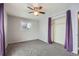 Neutral bedroom featuring gray carpet, gray walls, a ceiling fan and purple curtains surrounding the closet at 6374 Upham St, Arvada, CO 80003