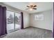 The primary bedroom features gray carpet, gray walls, a ceiling fan and a sliding glass door to the balcony at 6374 Upham St, Arvada, CO 80003