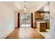 Kitchen view features wooden cabinetry, pendant lighting, and access to dining area at 6374 Upham St, Arvada, CO 80003