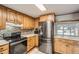 Kitchen featuring stainless steel appliances, wood cabinets, and a mosaic tile backsplash for a blend of style and functionality at 6374 Upham St, Arvada, CO 80003