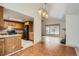 Kitchen view from dining room, featuring wooden cabinetry and black refrigerator at 6374 Upham St, Arvada, CO 80003