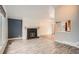 Cozy living room with a black brick fireplace, wood-look flooring, and an adjacent room visible through the pass-through at 6374 Upham St, Arvada, CO 80003