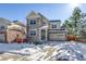 Two-story house with stone and siding exterior, two-car garage, and snowy front yard at 23320 E Berry Ave, Aurora, CO 80016