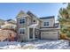 Two-story house with stone and siding exterior, two-car garage, and snowy front yard at 23320 E Berry Ave, Aurora, CO 80016