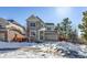 Two-story house with stone and siding exterior, two-car garage, and snowy front yard at 23320 E Berry Ave, Aurora, CO 80016