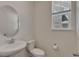 Neat half-bathroom with a sleek pedestal sink and a window for natural light at 640 Avena Dr, Elizabeth, CO 80107