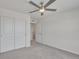 Bright bedroom featuring plush gray carpet, white walls, a ceiling fan, and a closet for ample storage at 640 Avena Dr, Elizabeth, CO 80107