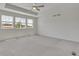 Spacious main bedroom featuring neutral carpet, tray ceiling and a ceiling fan at 640 Avena Dr, Elizabeth, CO 80107