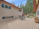 Large wooden back deck with table, chairs and wood pile at 7585 Native Dancer Trl, Evergreen, CO 80439