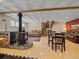 Finished basement with a wood-burning stove, leather couches, and dining table at 7585 Native Dancer Trl, Evergreen, CO 80439