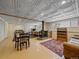 Finished basement with a wood-burning stove, exercise equipment, and a seating area at 7585 Native Dancer Trl, Evergreen, CO 80439