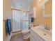 Bathroom featuring a shower with gold trim, white toilet and sink, and tile flooring at 7585 Native Dancer Trl, Evergreen, CO 80439