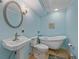 Charming blue bathroom featuring a clawfoot tub, modern sink, and patterned rug at 7585 Native Dancer Trl, Evergreen, CO 80439