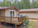 Back deck showcasing wooden railings and natural rock features at 7585 Native Dancer Trl, Evergreen, CO 80439