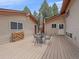 Outdoor deck area featuring a table with umbrella and wood storage rack at 7585 Native Dancer Trl, Evergreen, CO 80439
