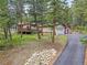 Charming exterior of home featuring a deck, garage, and scenic wooded surroundings at 7585 Native Dancer Trl, Evergreen, CO 80439