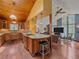 Open kitchen and living room area with a wooden ceiling, island, and stainless steel appliances at 7585 Native Dancer Trl, Evergreen, CO 80439