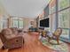 Comfortable living room boasts hardwood floors, large windows, and a relaxing ambiance at 7585 Native Dancer Trl, Evergreen, CO 80439