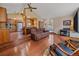Open-concept living room with hardwood floors, high ceilings, and seamless access to the kitchen at 7585 Native Dancer Trl, Evergreen, CO 80439
