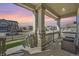 Cozy front porch with columns, stone accents, and outdoor seating, offering neighborhood views at 10992 Xanadu St, Commerce City, CO 80022