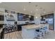 Stylish kitchen with a granite island, pendant lighting, and dark cabinetry at 10992 Xanadu St, Commerce City, CO 80022