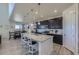 Modern kitchen with a large island, granite countertops, dark cabinets, and stainless steel appliances at 10992 Xanadu St, Commerce City, CO 80022