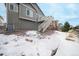 A spacious backyard with a wooden fence, snow and an elevated deck with stairs at 762 Tailings Dr, Monument, CO 80132