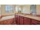 Bathroom with a tub, double sinks, and a large mirror at 762 Tailings Dr, Monument, CO 80132