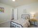 Bright bedroom with a floral-patterned bedspread, white walls, carpet floors, and a bedside table at 762 Tailings Dr, Monument, CO 80132