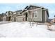 View of the home's exterior with a two-car garage, tasteful landscaping, and fresh snowfall at 762 Tailings Dr, Monument, CO 80132