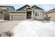 Charming home with a two-car garage, stone accents, and a well-maintained yard partially covered in snow at 762 Tailings Dr, Monument, CO 80132