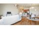 Bright living room with hardwood floors, a white sofa, and an open layout to the dining area at 762 Tailings Dr, Monument, CO 80132