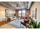 Spacious living room with exposed brick walls, industrial-style ceiling, hardwood floors, and a large window at 1801 Wynkoop St # 411, Denver, CO 80202