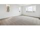Well-lit bedroom with neutral carpet and expansive windows showcasing mountain views at 8213 Butte Creek St, Littleton, CO 80125