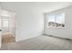 Minimalist bedroom boasts a large window with natural light and neutral carpet at 8213 Butte Creek St, Littleton, CO 80125