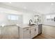Open kitchen with a central island, stainless steel dishwasher, and view into an adjacent living area at 8213 Butte Creek St, Littleton, CO 80125