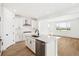 Bright, open kitchen featuring a stainless dishwasher, center island, and light wood flooring at 8213 Butte Creek St, Littleton, CO 80125