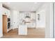 Modern white kitchen with stainless steel appliances, a center island, and wood floors at 8213 Butte Creek St, Littleton, CO 80125