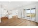 Open-concept living space with wood floors, white kitchen, and sliding doors to outdoor patio at 8213 Butte Creek St, Littleton, CO 80125
