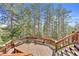 Wooden deck with built-in benches surrounded by tall pine trees at 900 Ballantine Rd, Golden, CO 80401