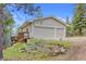 Exterior featuring a two-car garage, wooden planters and green grass at 900 Ballantine Rd, Golden, CO 80401