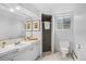 Functional basement bathroom with white tiled floors, a framed mirror, toilet and shower at 3666 S Jersey St, Denver, CO 80237