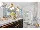 Beautiful bathroom with marble tiling, double vanity sinks, and modern gold lighting fixtures at 3666 S Jersey St, Denver, CO 80237