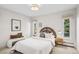 Inviting bedroom boasts neutral walls, natural light, and a charming, bohemian-style headboard at 3666 S Jersey St, Denver, CO 80237