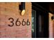 Close-up of house number 3666 and a modern light fixture on a brick exterior at 3666 S Jersey St, Denver, CO 80237
