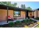 Charming brick home with a covered entryway, manicured landscaping, and a cozy outdoor seating area at 3666 S Jersey St, Denver, CO 80237