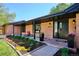Inviting front entrance with a well-manicured garden, brick facade, and a cozy seating area on the covered porch at 3666 S Jersey St, Denver, CO 80237