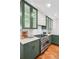 Close-up of the kitchen featuring modern stainless steel range, quartz countertops and green cabinets at 3666 S Jersey St, Denver, CO 80237