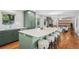 Spacious kitchen island with bar seating, quartz countertop, modern cabinetry, and hardwood flooring at 3666 S Jersey St, Denver, CO 80237