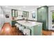 Well-designed kitchen with a large island, modern appliances, and stylish green cabinetry at 3666 S Jersey St, Denver, CO 80237